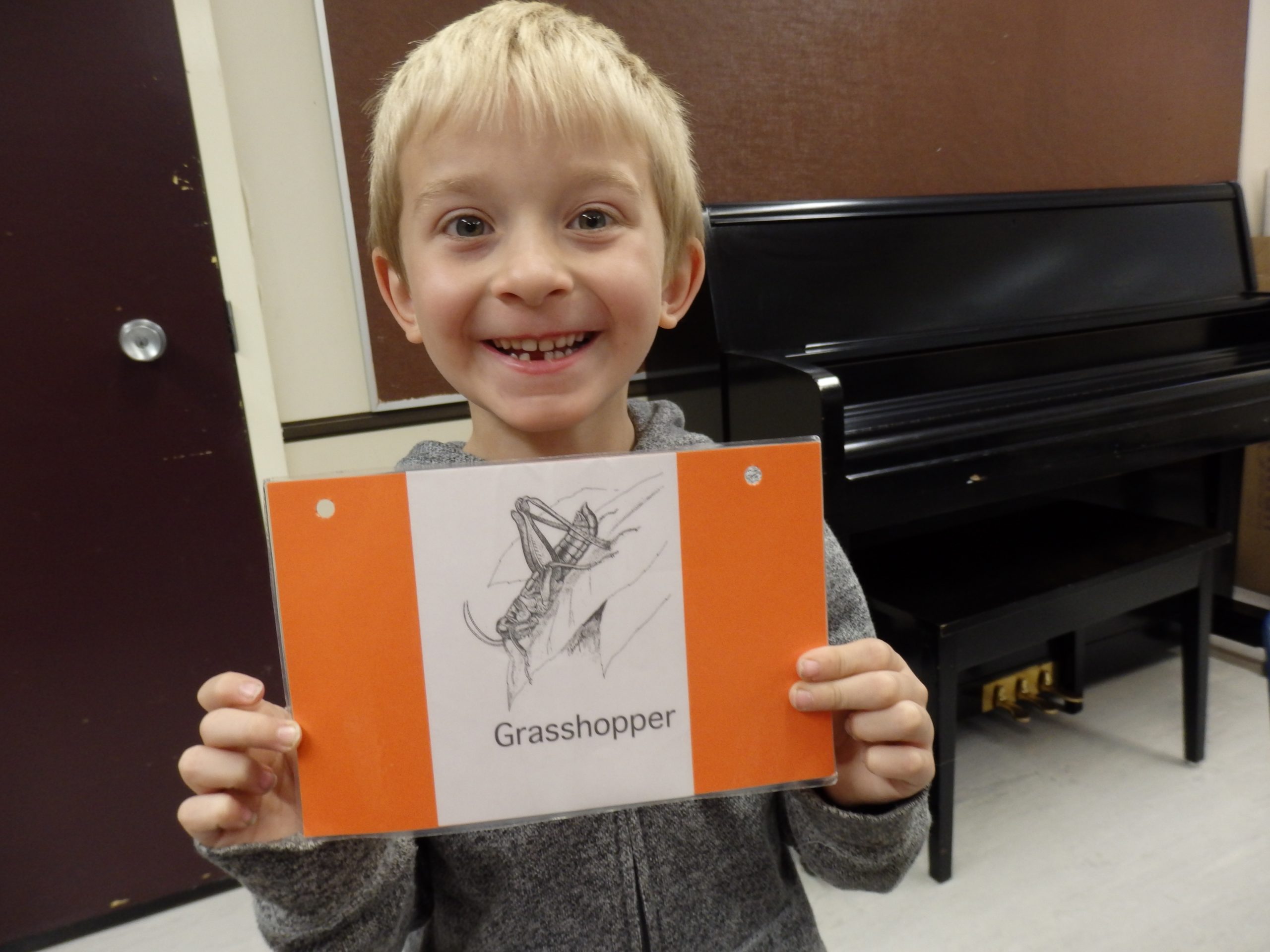Student holding grasshopper sign for who am I activity